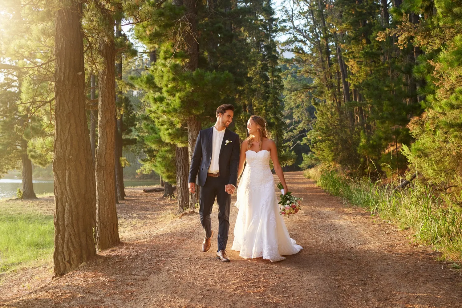 Bride and groom walking on forest path