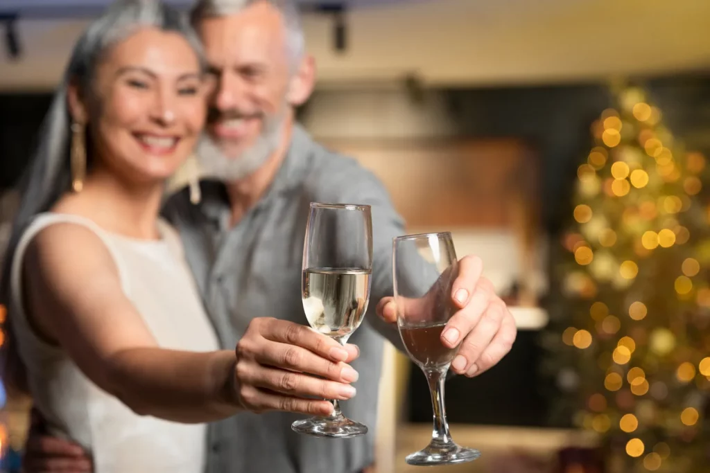 Couple toasting with champagne near Christmas tree