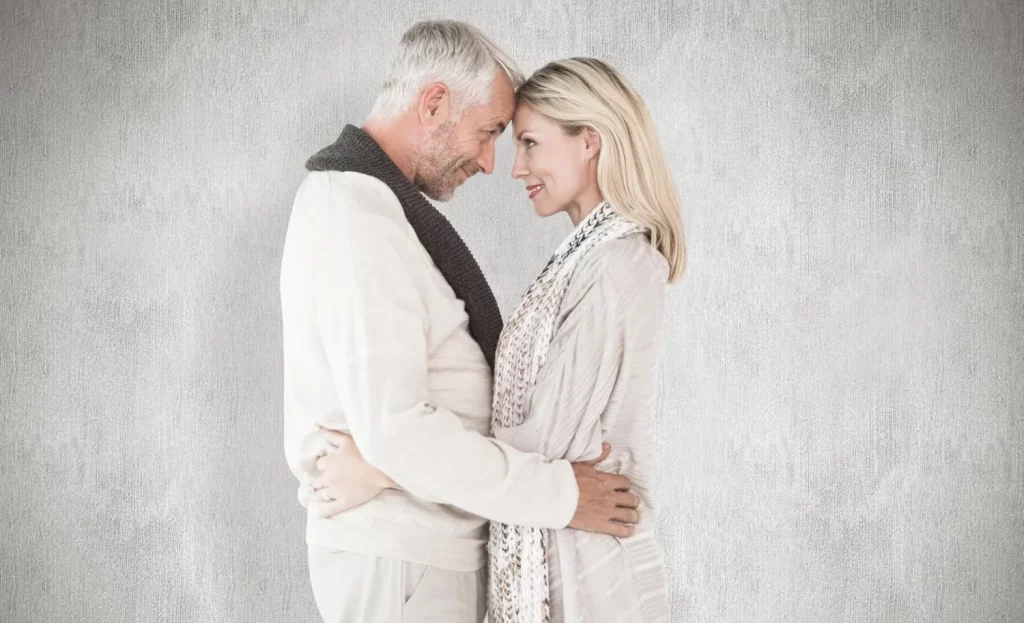 Mature couple embracing and touching foreheads indoors