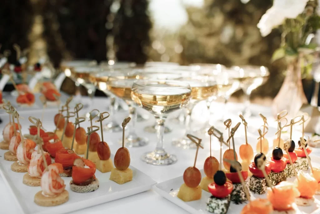Champagne glasses and assorted appetizers on outdoor table