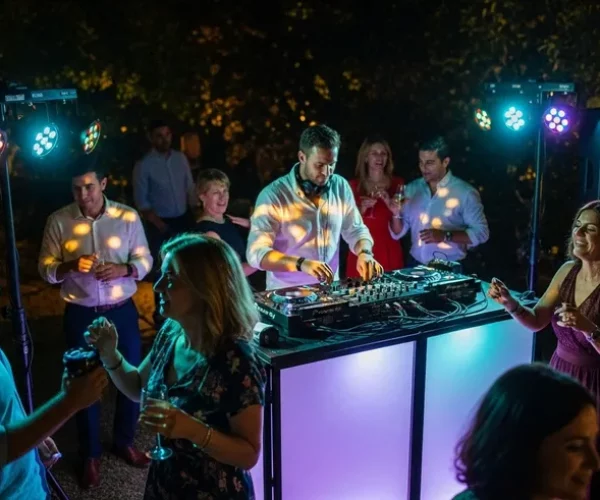 bonkers image a nighttime outdoor DJ playing music at outdoor party with lights.