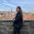 paula resenas whitelion Person enjoys city view from a stone balcony.